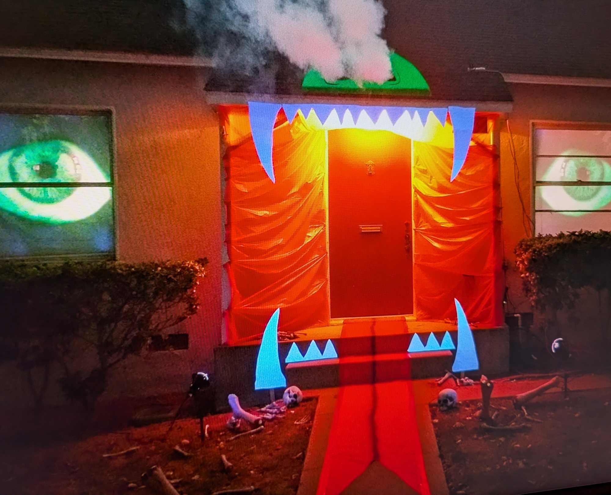 House facade dressed as a monster for Halloween, glowing eyes in the windows and fangs around the door