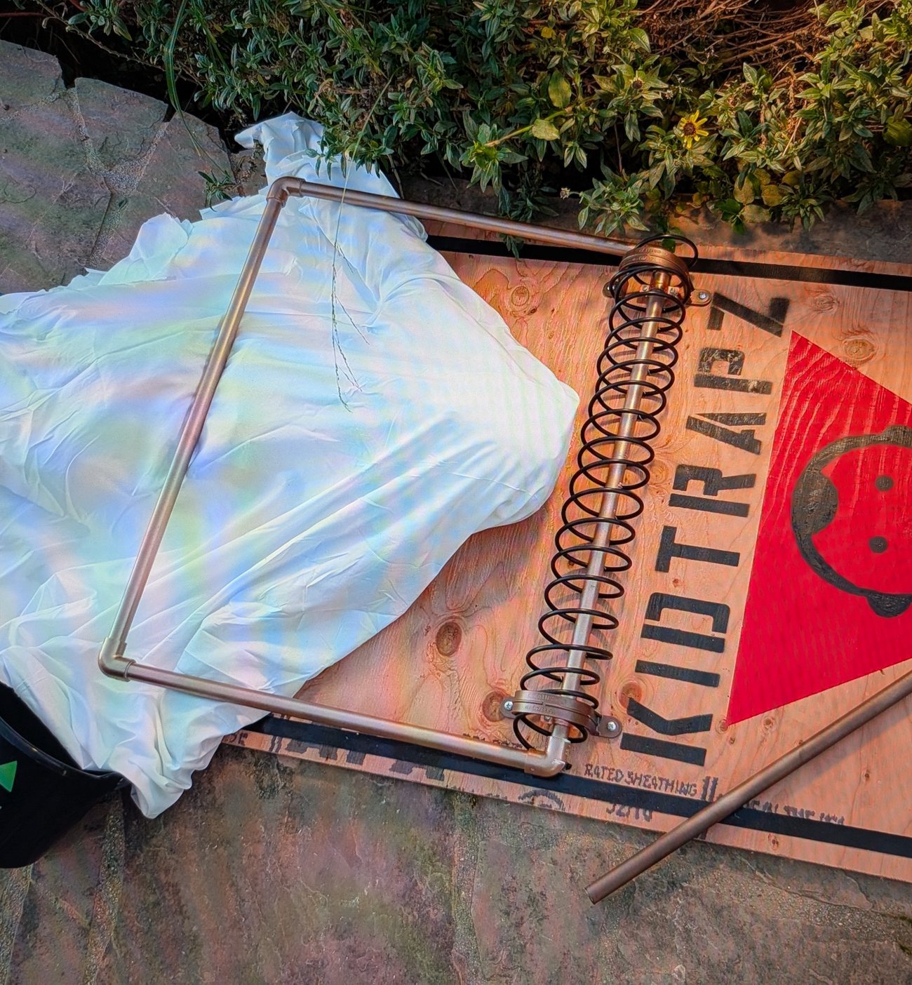 Oversized KidTrapz mousetrap prop with a figure under a white sheet caught beneath the bar